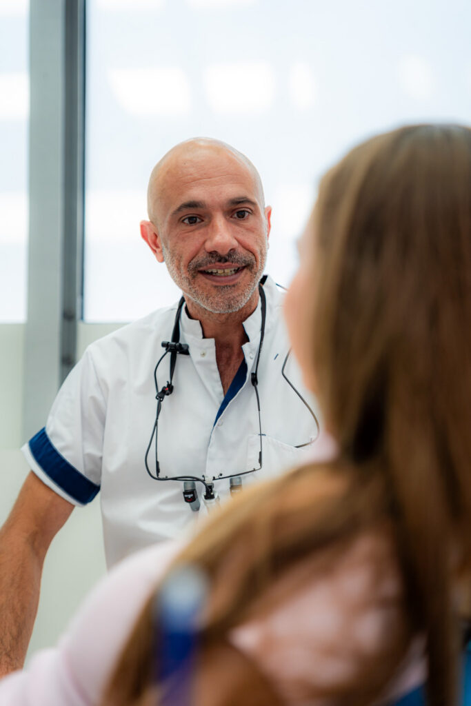 Tandarts bespreekt een klikgebit op implantaten met een patiënt in Schiedam